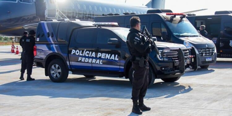 Agentes da Polícia Penal Federal em operação com viaturas e aeronave ao fundo.