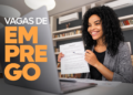 Mulher sorridente segurando contrato e caneta durante entrevista online para vaga de emprego