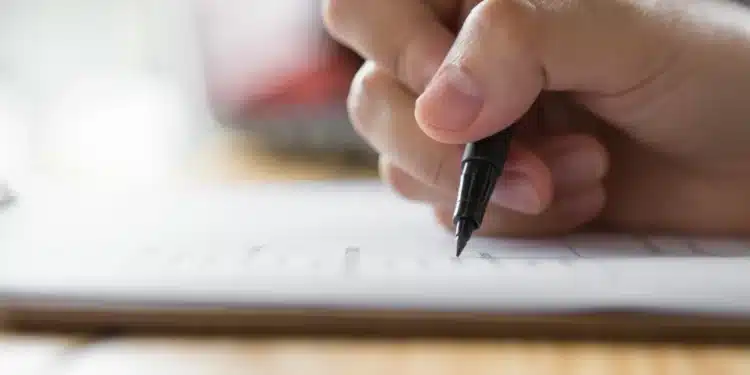 Pessoa preenchendo um formulário, ilustrando orientações para conferir o local da prova discursiva do CNU 2025.