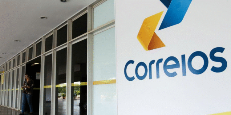 Entrada da agência dos Correios com logo colorida em destaque na parede branca.