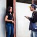 Recenseador do IBGE conversando com moradora na porta de sua casa durante coleta de dados do Censo 2020.