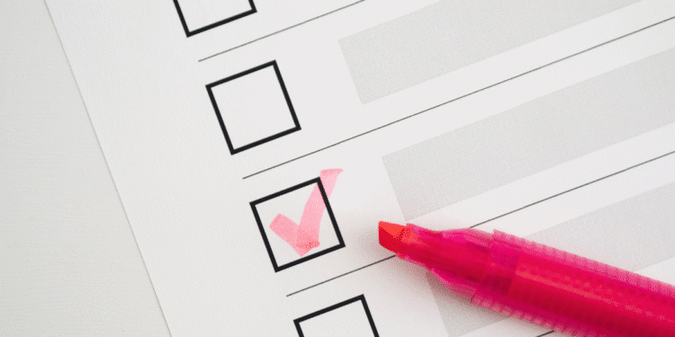 Caneta marca-texto rosa marcando um quadrado em uma lista de verificação em papel branco