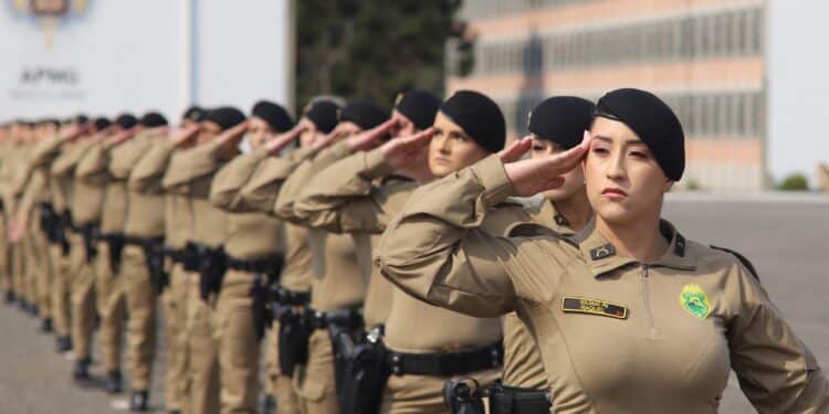 Soldadas da Polícia Militar do Paraná alinhadas em formação militar, saudando com uniforme e boina preta