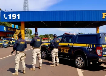 Agentes da Polícia Rodoviária Federal em operação com viaturas oficiais e a base policial ao fundo