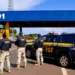 Agentes da Polícia Rodoviária Federal em operação com viaturas oficiais e a base policial ao fundo