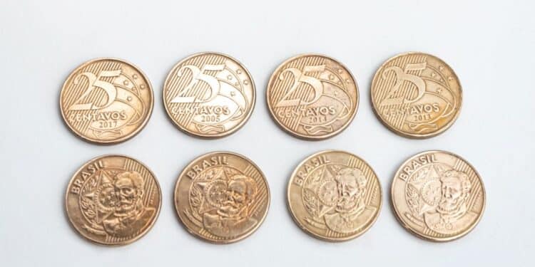 Quatro moedas brasileiras de 25 centavos alinhadas na parte superior e quatro na parte inferior, mostrando o anverso e o reverso. A imagem ilustra a busca por moedas raras com erro de cunhagem na numismática.
