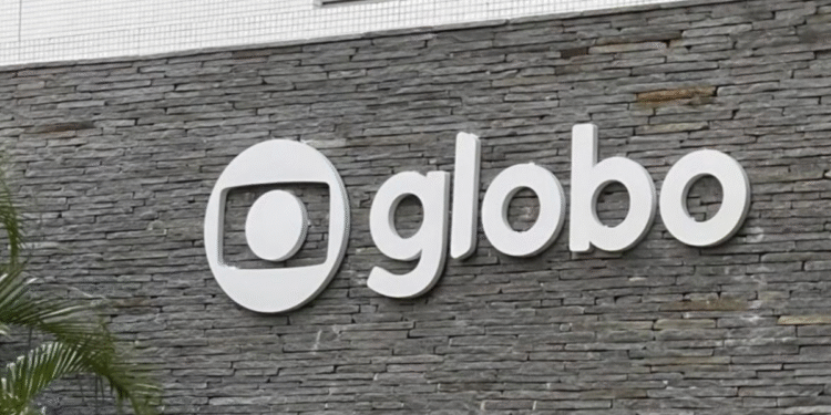 Logo branco da emissora Globo fixado em parede de pedra cinza