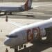 Avião da companhia aérea GOL na ponte de embarque no aeroporto com equipe de solo