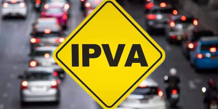 Placa amarela de trânsito em formato de losango com a sigla IPVA escrita em preto, sobreposta a uma imagem desfocada de congestionamento de carros à noite com luzes vermelhas acesas.