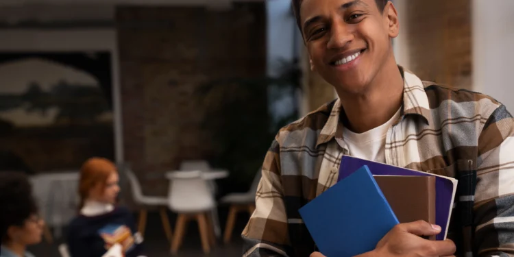 Estudante sorridente segurando livros, refletindo sobre sua futura profissão.
