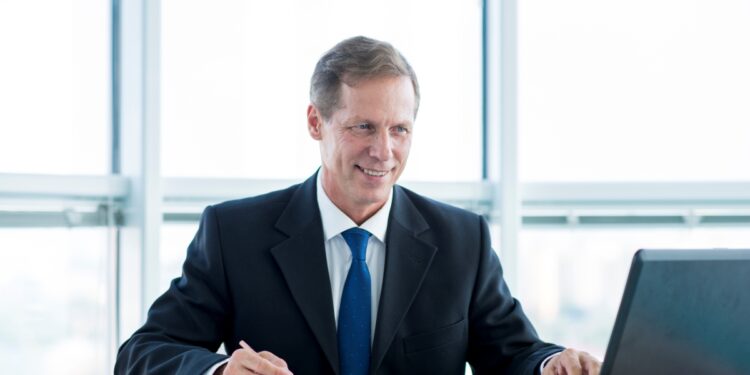 Profissional de sucesso trabalhando em escritório moderno com computador e documentos, destacando as carreiras promissoras de 2026.