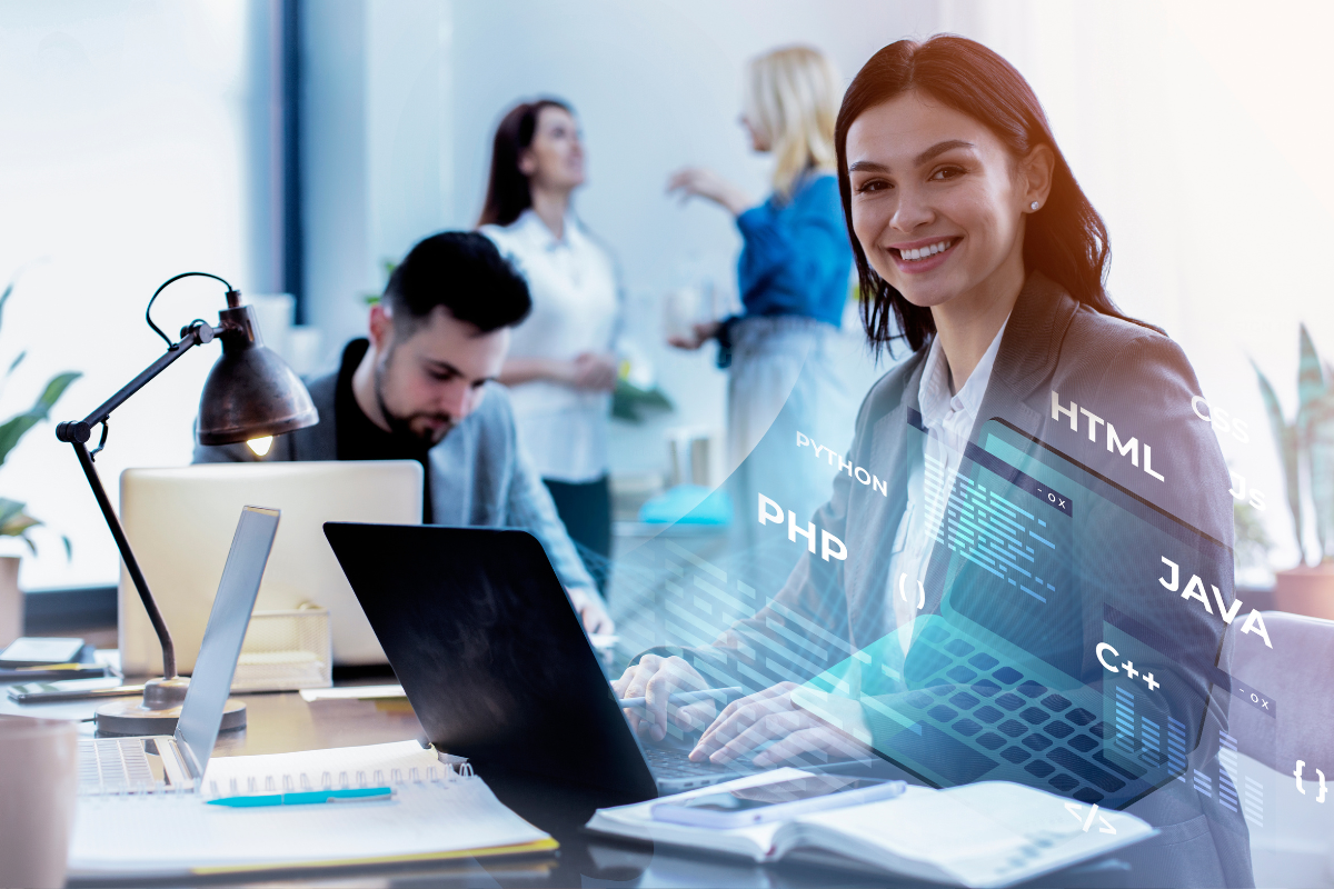 Profi Mulher jovem e sorridente usando laptop em ambiente de escritório com colegas e holograma de códigos de programação