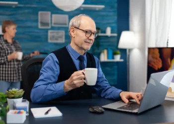 Profissional maduro trabalhando no notebook enquanto planeja uma transição de carreira aos 50 anos.