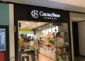 Fachada da loja Cacau Show em shopping, com vidros transparentes mostrando chocolates e produtos na exposição