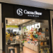 Fachada da loja Cacau Show em shopping, com vidros transparentes mostrando chocolates e produtos na exposição