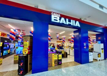 Entrada da loja Casas Bahia com colunas em azul e displays de eletrônicos com etiquetas de oferta