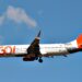 Avião comercial da Gol Linhas Aéreas com logo laranja e branco voando sob céu azul com poucas nuvens