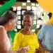 Aposentados e pensionistas do INSS, sorrindo e celebrando a antecipação do 13º salário em 2026, com fundo decorado.