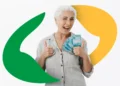 Mulher idosa sorrindo e segurando notas de 100 reais, simbolizando o pagamento do 13º salário do INSS em 2026.