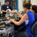 Trabalhadores em linha de produção industrial, realizando tarefas de montagem em ambiente de fábrica.