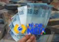 Cédulas de 100 reais e logo do programa Pé-de-Meia, que ilustra o pagamentos aos concluintes do ensino médio em 2026.