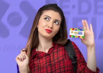 Estudante da EJA segura cartão do programa Pé-de-Meia em referência ao possível pagamento de R$ 1.000 em 2026.