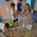 Professora interagindo com crianças pequenas durante atividade lúdica em creche