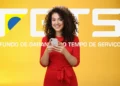 Mulher sorridente segurando celular em frente ao logo do FGTS para consultar saque-aniversário.