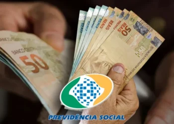 Nota de 50 reais em mãos com o logotipo da Previdência Social, destacando o reajuste do INSS para 2026, com aumento de até R$ 8.475,54 para beneficiários.