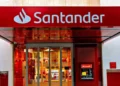 Fachada de agência do Banco Santander com entrada e caixa eletrônico.