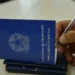 Carteira de Trabalho e Previdência Social sendo preenchida com caneta, representando o processo de solicitação do Seguro-Desemprego.