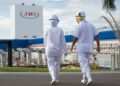 Funcionários da JBS caminhando em frente à unidade industrial da empresa