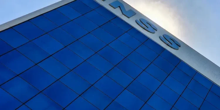 Fachada de agência do INSS com prédio espelhado azul representando comunicado de fechamento das unidades de atendimento