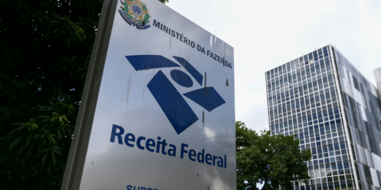 Placa da Receita Federal com o logo do Ministério da Fazenda em frente a um prédio moderno