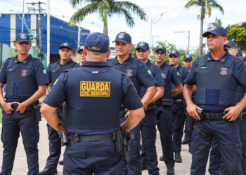 Grupo de agentes da Guarda Civil Municipal alinhados e uniformizados em área externa
