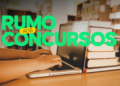 Mãos digitando em notebook ao lado de livros, com a frase "Rumo aos Concursos" ao fundo.