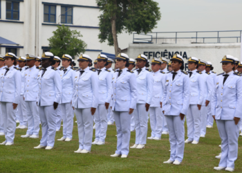 Oficiais femininas da Marinha do Brasil em formação, vestindo uniformes brancos em campo gramado