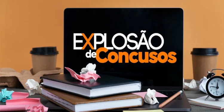 Mesa com livros, anotações, xícaras e notebook exibindo o texto "Explosão de Concursos"
