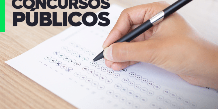 Mão preenchendo cartão-resposta de concurso público em 2026