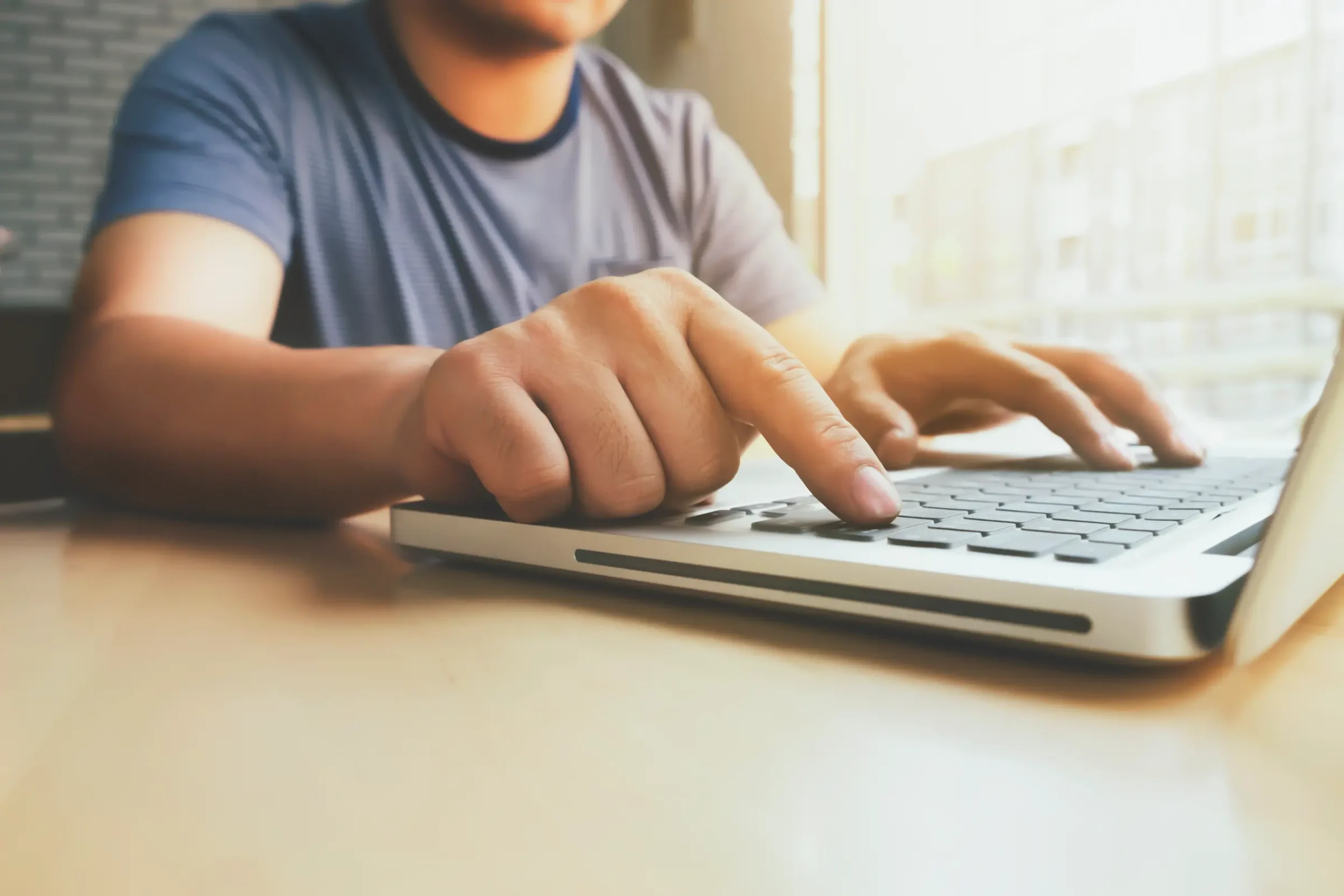 Concursos Tribunais de Justiça – Pará e Rio de Janeiro Pessoa digitando em laptop, representando a participação em concursos públicos dos Tribunais de Justiça.