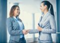 Profissionais apertando as mãos em um ambiente de escritório, representando o crescimento nas oportunidades de emprego e no mercado de trabalho.