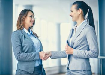 Profissionais apertando as mãos em um ambiente de escritório, representando o crescimento nas oportunidades de emprego e no mercado de trabalho.