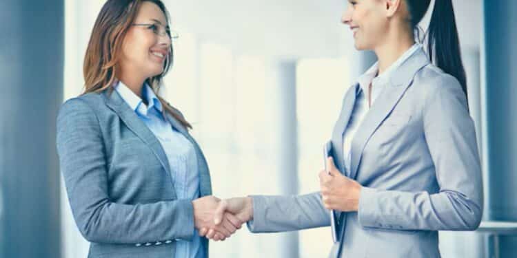 Profissionais apertando as mãos em um ambiente de escritório, representando o crescimento nas oportunidades de emprego e no mercado de trabalho.