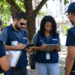 Equipe do IBGE com pranchetas e tablet durante atividade de campo em área urbana.