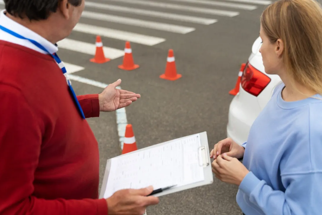 Abolição do teste de baliza na CNH - Detran Instrutor e aluno durante a prova prática de direção, com cones de trânsito no teste de baliza.