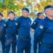 Grupo de guardas municipais alinhados em formação usando uniforme azul e boina preta em área externa.