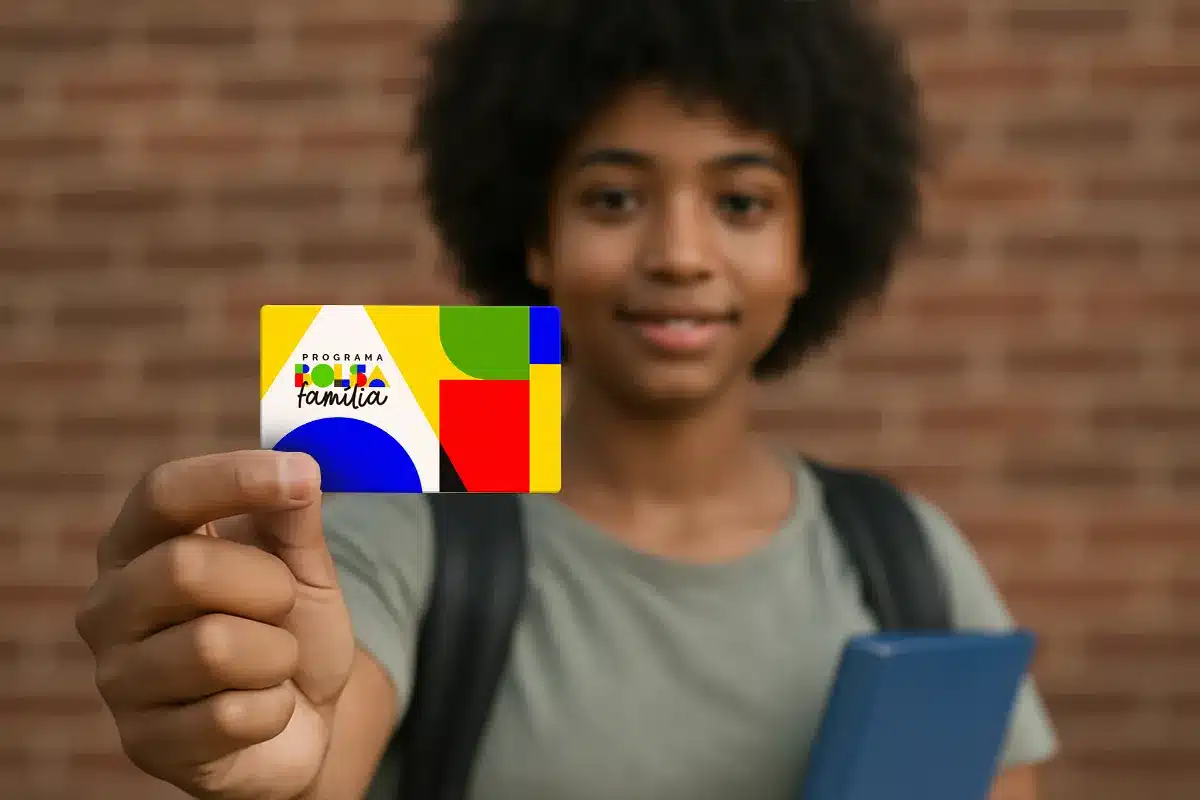 Novas regras do Bolsa Família reforçam controle da frequência escolar Estudante segurando cartão do Bolsa Família representando as novas regras de acompanhamento da frequência escolar definidas pelo governo federal.