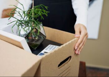 Pessoa com uma caixa de mudanças, simbolizando a transição de carreira e a busca por novas oportunidades de emprego em 2026.