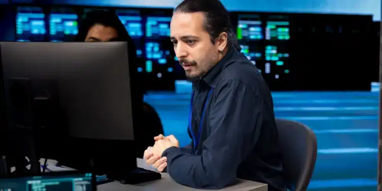 Profissional de TI monitorando sistemas em um ambiente de data center, representando o crescimento das vagas e aumento salarial no setor tecnológico.