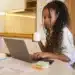 Profissional trabalhando de casa, analisando gráficos e tomando café em um ambiente doméstico com laptop.